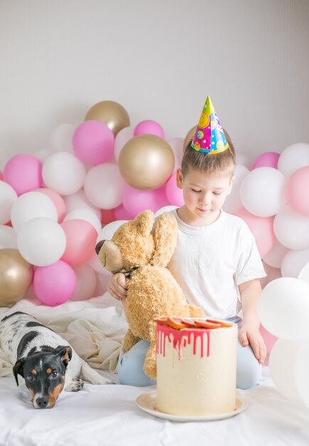 Kleiner Junge in weißen Luftballons mit ihm Hund