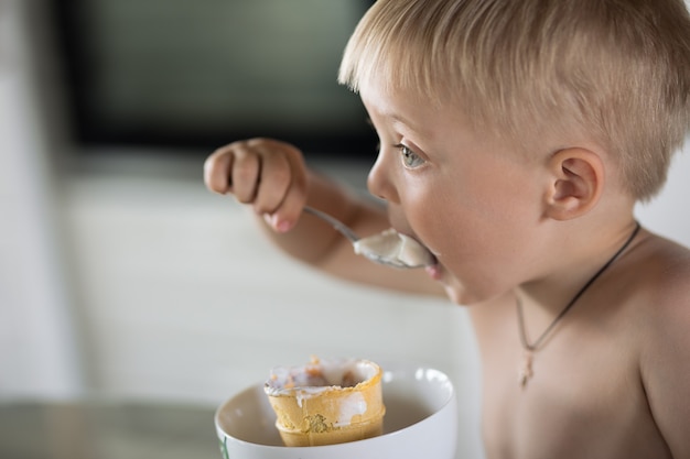 Foto kleiner junge isst einen löffel eis