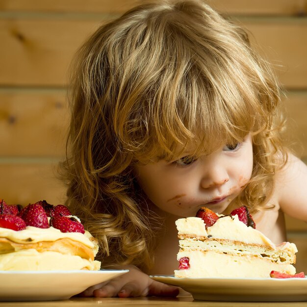 Kleiner Junge isst Erdbeerkuchen