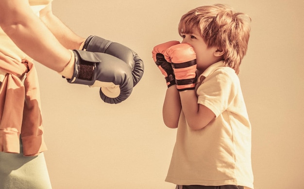 Kleiner Junge macht Boxübungen mit Großvater Vater trainiert seinen Sohn beim Boxen Kleiner Junge Sportler beim Boxtraining mit Trainer