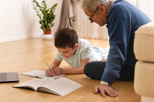 Foto kleiner junge macht hausaufgaben mit seinem großvater zu hause