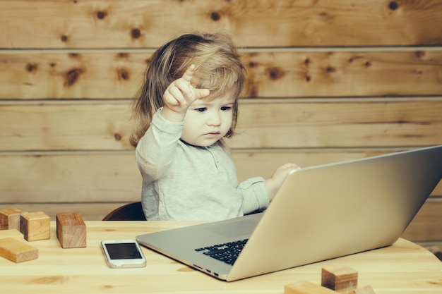 Kleiner Junge mit Computer und Telefon