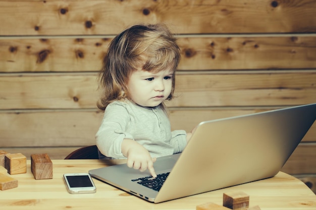 Kleiner Junge mit Computer und Telefon