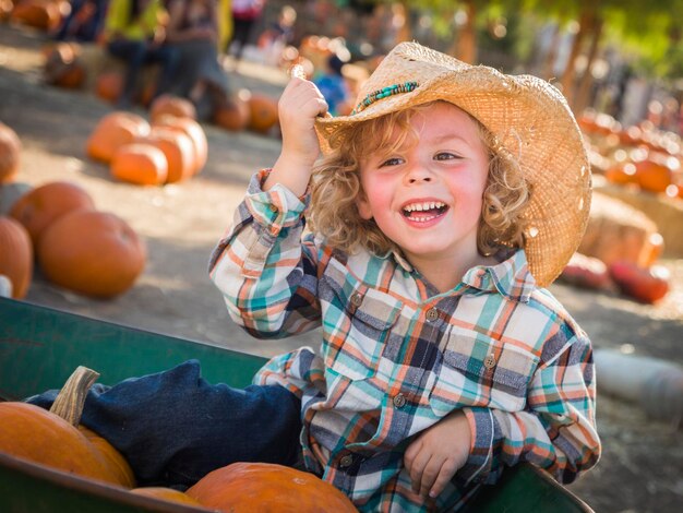 Foto kleiner junge mit cowboyhut in pumpkin patch