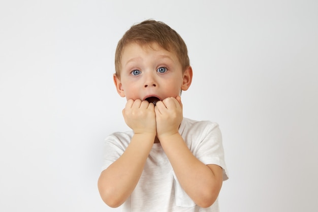 Kleiner Junge mit den blauen Augen steckte erschrocken die Hände in den Mund