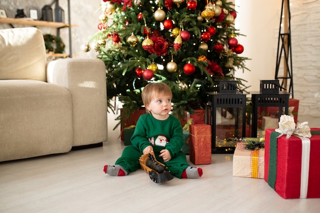 Kleiner Junge mit Geschenkboxen und Weihnachtsbaum