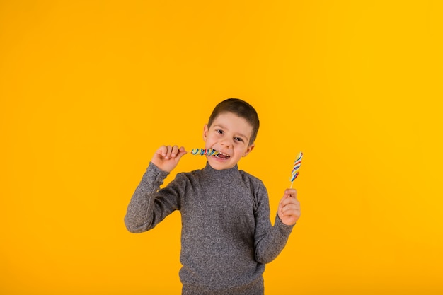 Kleiner Junge mit Lutschern in den Händen