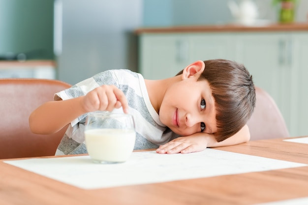 Kleiner Junge mit Milch in der Küche