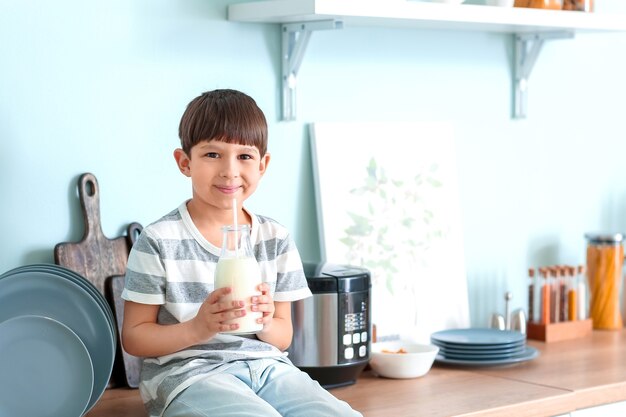 Kleiner Junge mit Milch in der Küche