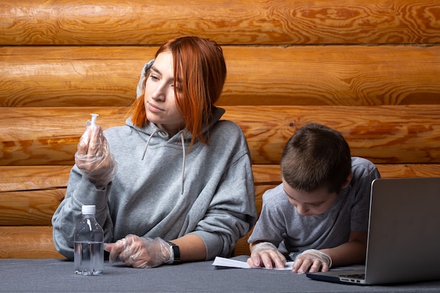 Kleiner Junge mit Mutter liest Anweisungen für Laborarbeit