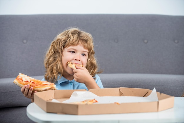 Kleiner Junge mit Pizzakartons Junge bereit, Pizza zu essen Kleines Kind, das eine Pizzaschachtel betrachtet Kleiner Junge, der Pizza isst Netter kleiner Junge isst Pizzas Glücklicher hübscher junger jugendlich Junge, der Scheibe Pizza hält