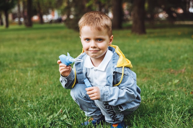 Kleiner Junge mit Seifenblasen im Park Frühling sonniger Tag aktive Spiele für Kinder