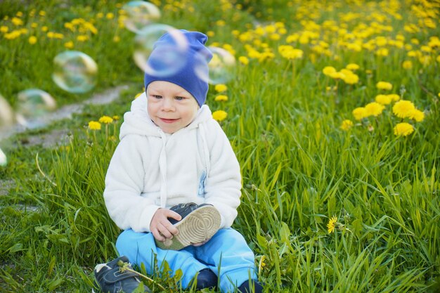 Kleiner Junge mit Seifenblasen im Park