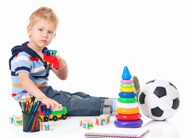 Kleiner Junge mit Spielzeug isoliert auf weißem Hintergrund