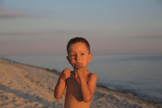 Kleiner Junge mit Süßigkeiten auf dem Meer