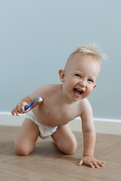 Foto kleiner junge putzt seine zähne mit einer zahnbürste und lacht