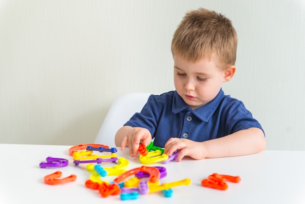 Kleiner Junge schafft neues Design aus hellen Plastikblöcken