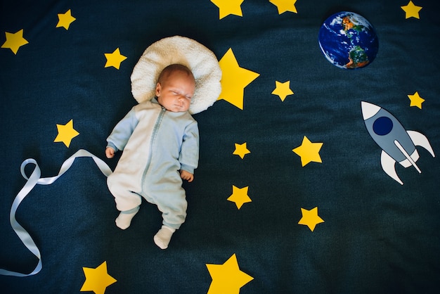 Kleiner Junge schläft und träumt sich einen Astronauten im Weltraum
