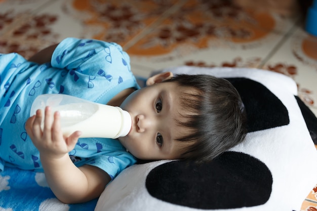 Foto kleiner junge schläft und trinkt milch.