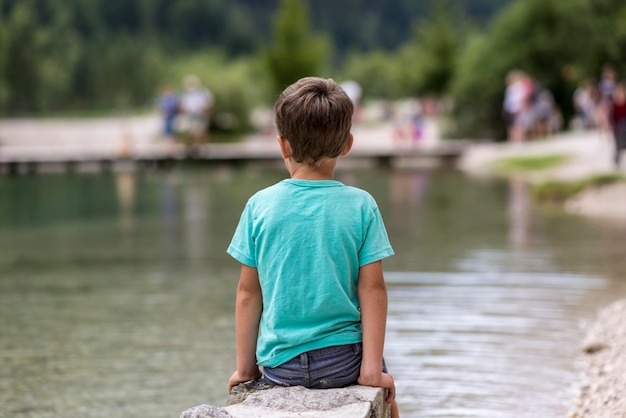 Kleiner Junge sitzt am See