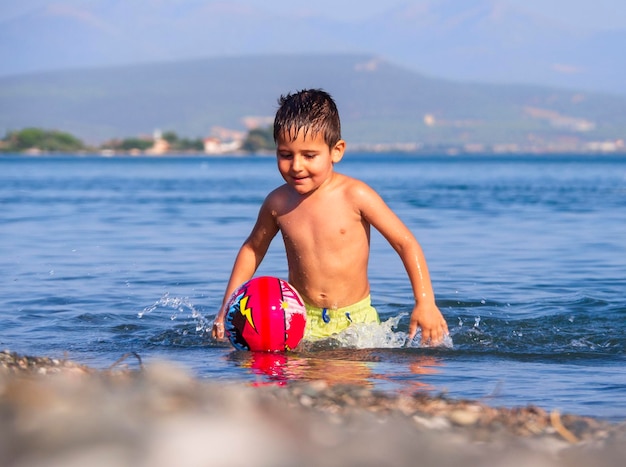 Kleiner Junge spielt im Ägäischen Meer auf einer griechischen Insel