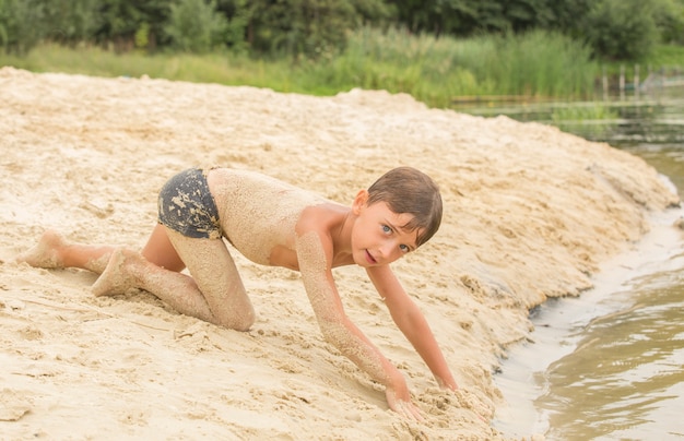 Foto kleiner junge spielt im sand