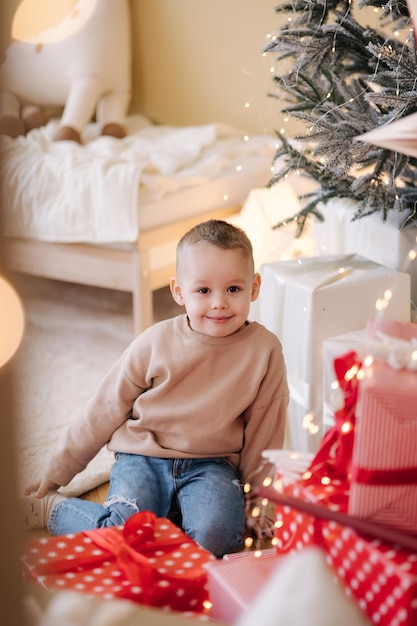 Kleiner Junge spielt im Zimmer seines Kindes Dekoriertes Zimmer für Weihnachtsferien