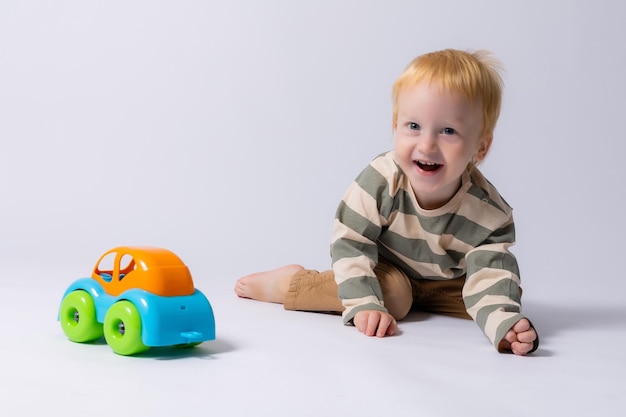 kleiner Junge spielt mit einer Schreibmaschine auf einem weißen Hintergrund