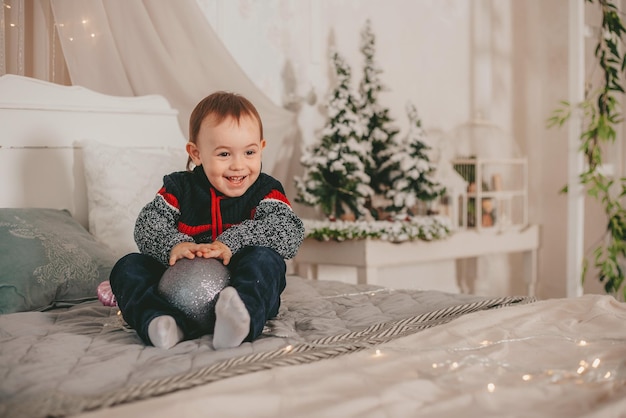 kleiner Junge spielt mit Spielzeug in Weihnachtsschmuck