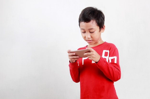 Kleiner Junge spielt Spiele auf dem Smartphone