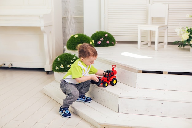 Kleiner Junge spielt zu Hause mit Spielzeugauto.