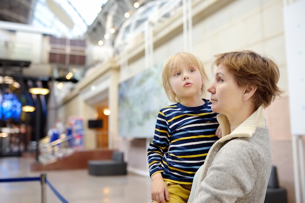 Kleiner Junge und Frau, die eine Ausstellung in einem wissenschaftlichen Museum suchen