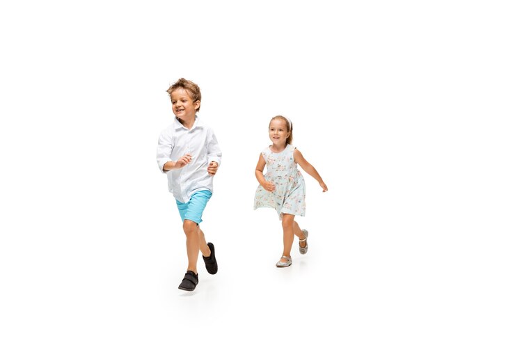 Foto kleiner junge und mädchen, die auf weißem hintergrund laufen, glücklich
