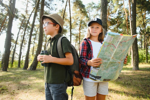 Kleiner Junge und Mädchen gehen auf einem Waldweg wandern