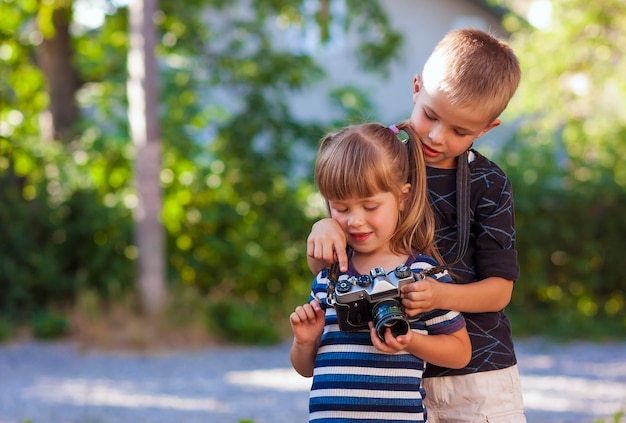 Kleiner Junge und Mädchen lernen, wie man Fotokamera benutzt