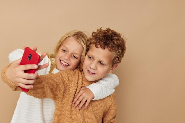 Kleiner Junge und Mädchen umarmen Unterhaltungs-Selfie, das unveränderte Freundschaftskindheit aufwirft