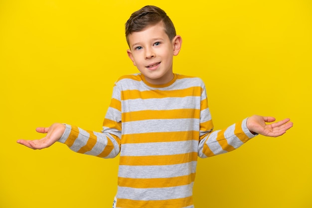 Kleiner kaukasischer Junge isoliert auf gelbem Hintergrund glücklich und lächelnd