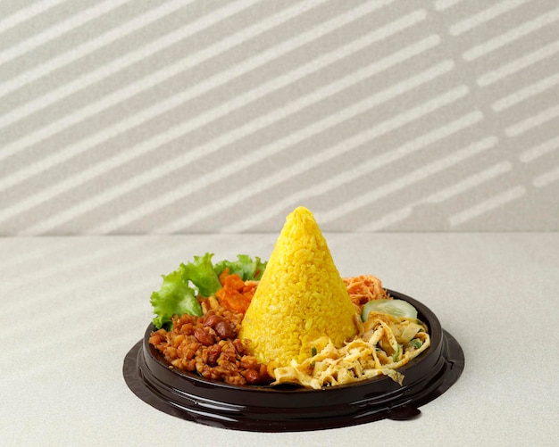 Kleiner kegelförmiger gelber Reis oder Tumpeng Mini Nasi Kuning Indonesisches festliches Essen für den Unabhängigkeitstag Indonesiens