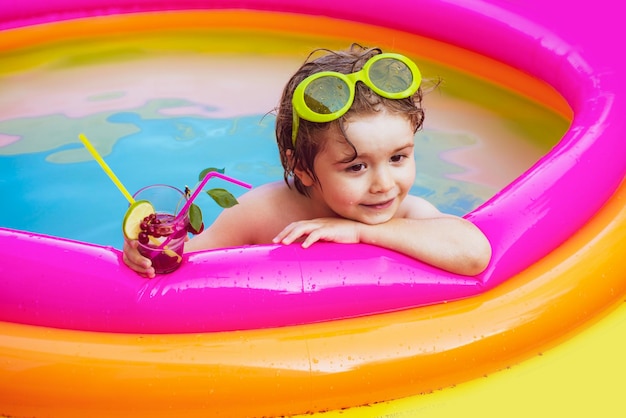 Kleiner Kinderjunge, der Spaß im Pool hat süßes Kind, das sich im Schwimmbad entspannt Kinder, die im Pool spielen ...