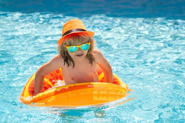 Kleiner Kinderjunge im Swimmingpool mit aufblasbarem Spielzeugring Kinder Sommerurlaub schwimmen für Kind o