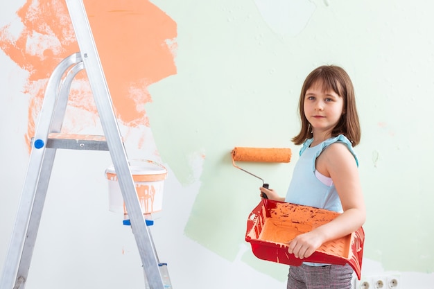 Kleiner Kindermaler, der Renovierungswand tut. Konzept für Renovierung, Reparatur und Neulackierung.