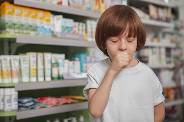 Kleiner kranker Junge in der Apotheke