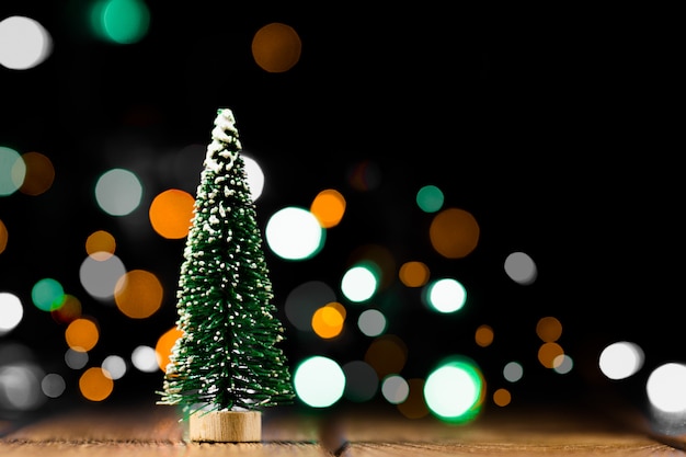 Kleiner künstlicher Weihnachtsbaum mit hellem bokeh Hintergrund.