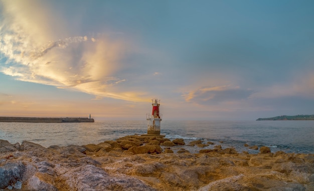 Kleiner Leuchtturm am Meer bei Sonnenuntergang