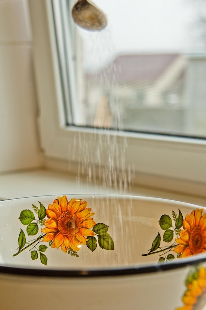 Foto kleiner löffel schüttet zucker in eine gemalte schüssel in der küche in der nähe vertikal