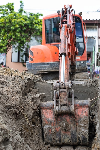 Kleiner Löffelbagger gräbt ein Loch auf Baustelle