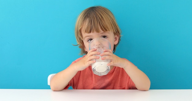 Kleiner netter Junge trinkt Milch