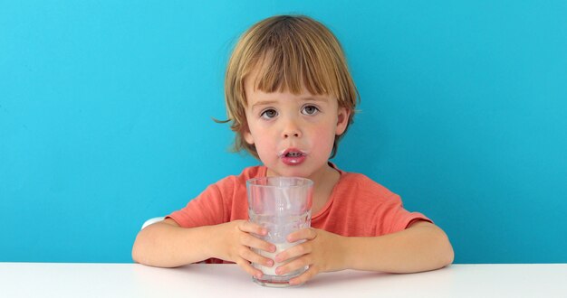 Kleiner netter Junge trinkt Milch