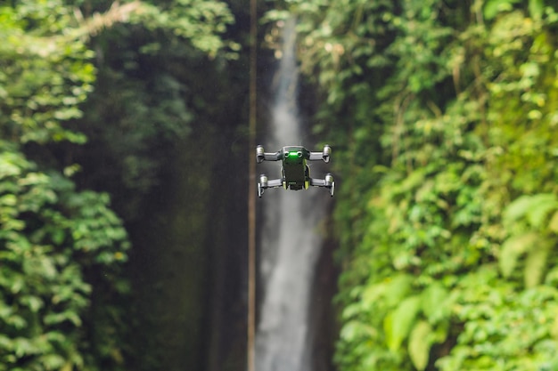 Kleiner Quadrocopter, der um den Wasserfall Leke Leke Bali Island Indonesien fliegt