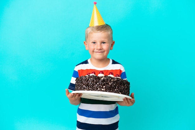 Kleiner russischer Junge mit Geburtstagstorte vor isoliertem Hintergrund